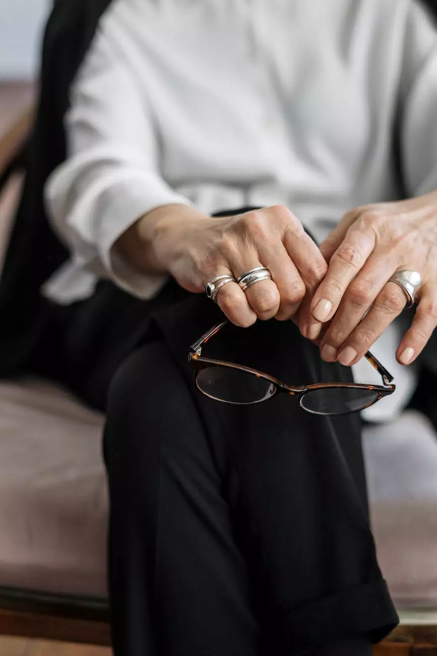 A seated person holding their glasses, taking a quiet pause